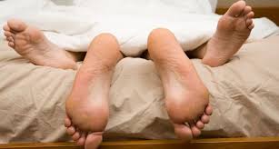 feet of a couple on bed